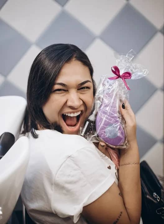 Participante sorrindo com um presente do Club Petrazza
